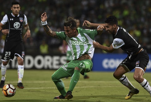 Dayro Moreno, del Nacional, compite por el balón con Juan Isaurralde, del Colo Colo, durante el partido por Copa Libertadores, en Medellín / AFP