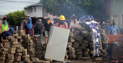 Manifestantes en contra del gobierno del presidente Daniel Ortega se protegen de la represión de la Policía en Masaya