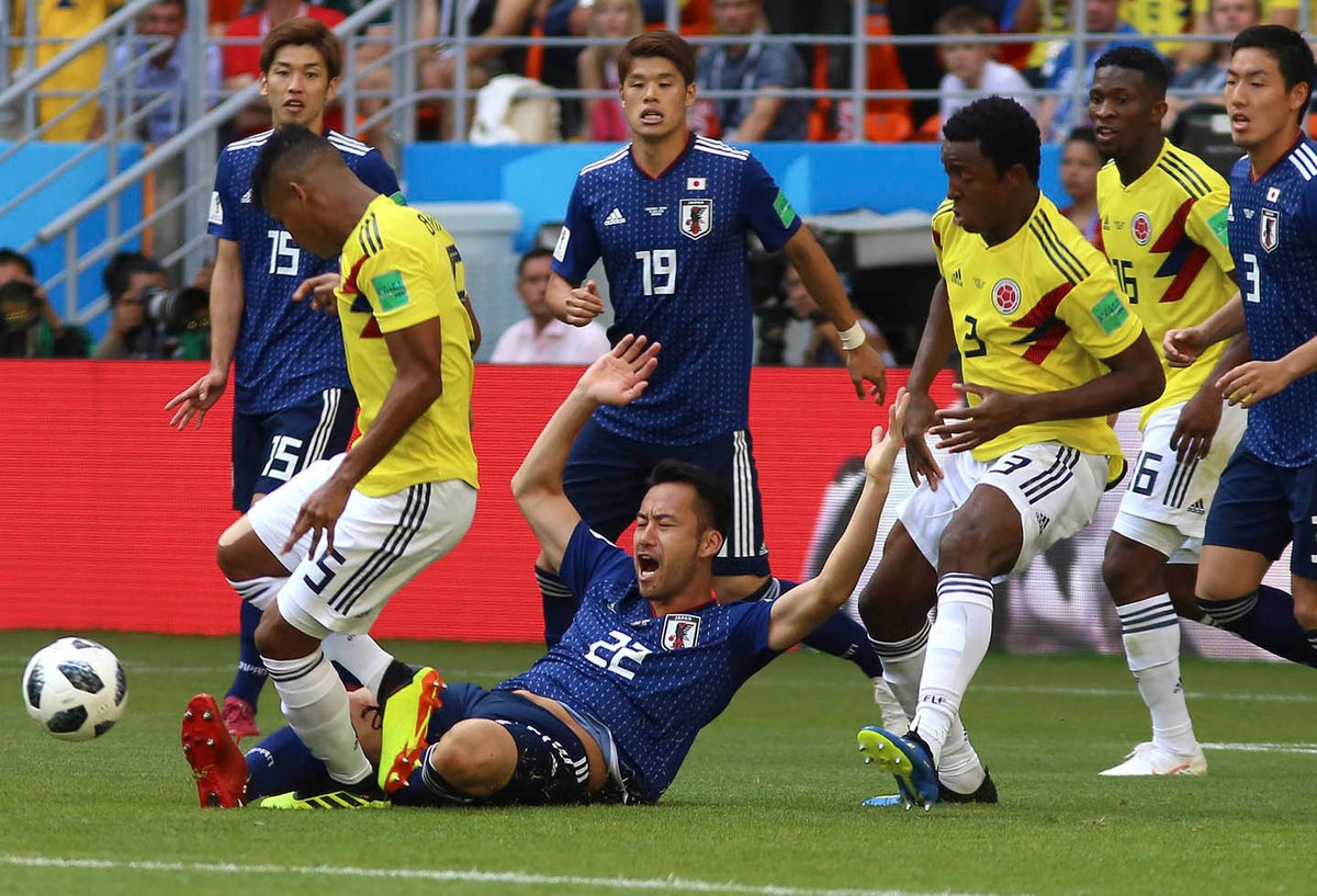 Los jugadores de Colombia disputando un balón con los japoneses