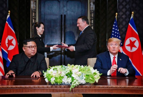 En el fondo Mike Pompeo; en la mesa Kim Jong Un y Donald Trump