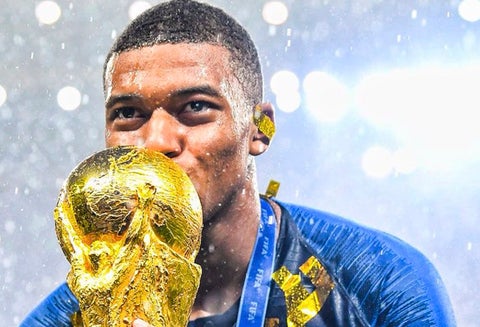 Kylian Mbappé besando la Copa del Mundo