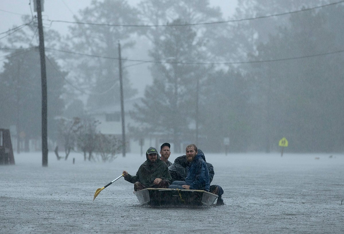 Personas navegando sobre las aguas que dejó Florence