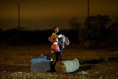 Una migrante venezolana junto a su hijo, vía Panamericana.