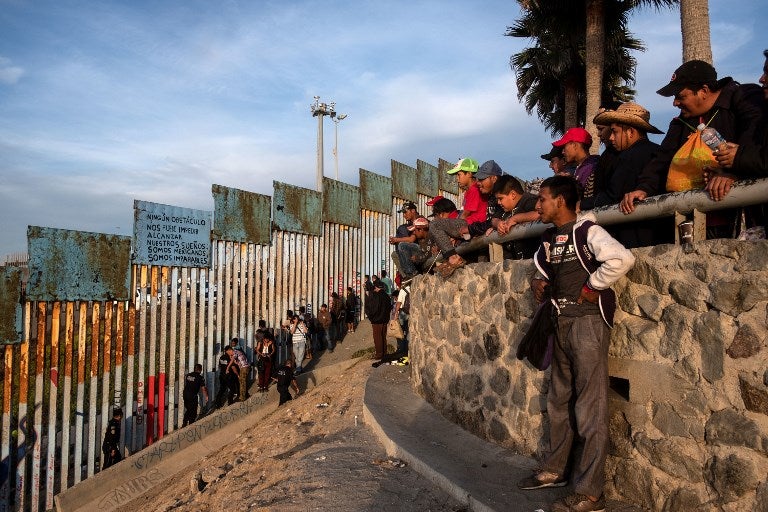 Migrantes centroamericanos en muro de Estados Unidos