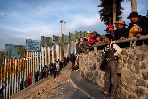 Migrantes centroamericanos en muro de Estados Unidos