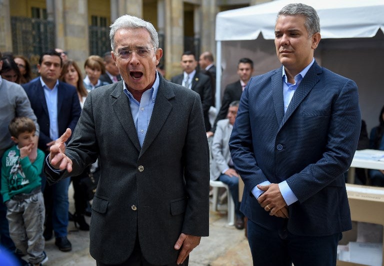 Ex senador Álvaro Uribe (izq.) y presidente Iván Duque
