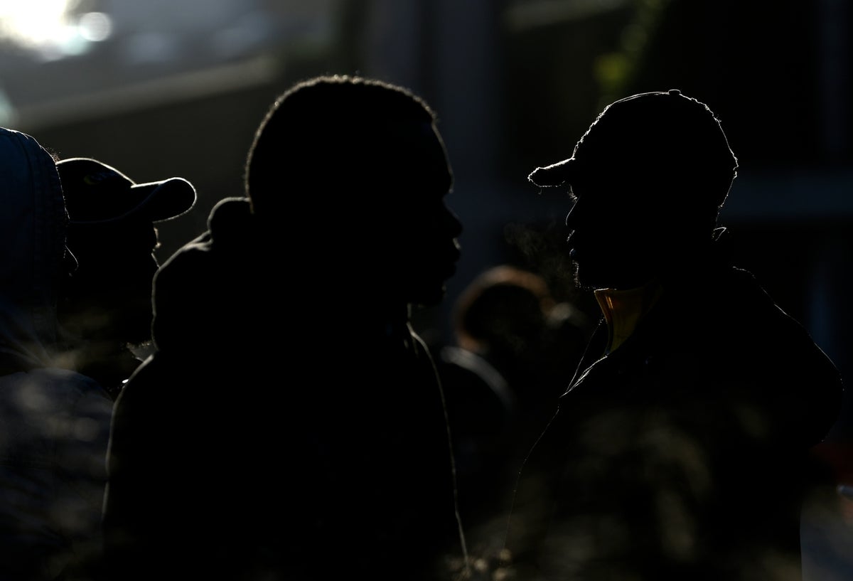 Los migrantes esperan durante la evacuación de una antigua fábrica de penicilina donde los migrantes de África, pero también italianos, vivían en condiciones precarias. Fuerzas policiales, carabinieri, policía municipal y bomberos participaron en la evacuación el 10 de diciembre de unos 40 migrantes restantes de varias nacionalidades de la fábrica abandonada, ya que cientos de otros se habían ido en los últimos días.