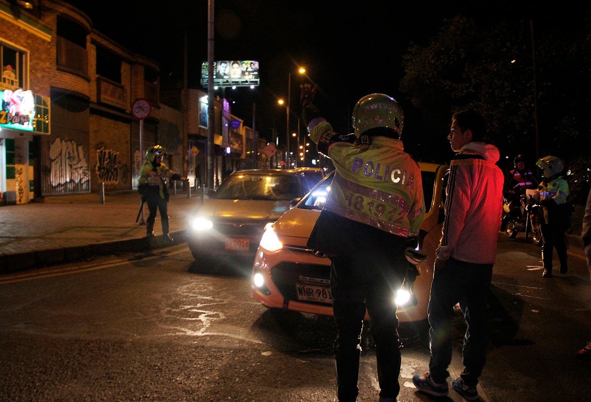 Un vehículo particular al costado de un taxi y con presencia de la Policía, en Bogotá
