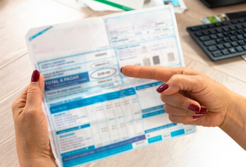 Colombiano mirando una factura de uno de sus servicios públicos