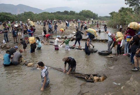 Venezolanos cruzando la frontera por el río