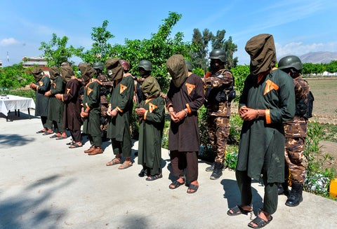 Miembros de las fuerzas de seguridad afganas respaldan a los presuntos combatientes del Estado Islámico en la provincia de Nangarhar, el 10 de abril de 2019