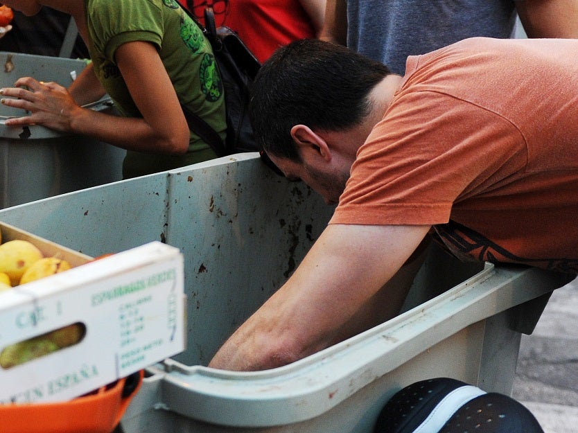 Personas buscando comida en la basura