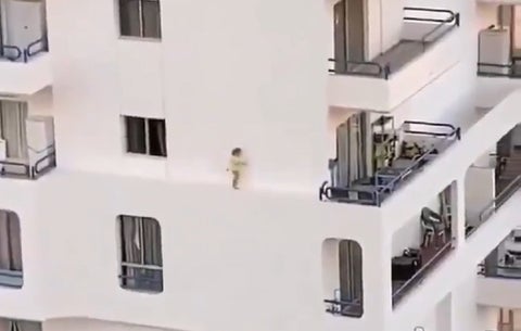 Niña caminando por el estrecho borde de un edificio