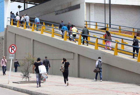 Personas entrando y saliendo de un centro comercial.