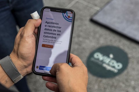 Un hombre usa la aplicación Coronapp utilizada en Colombia, durante la pandemia.