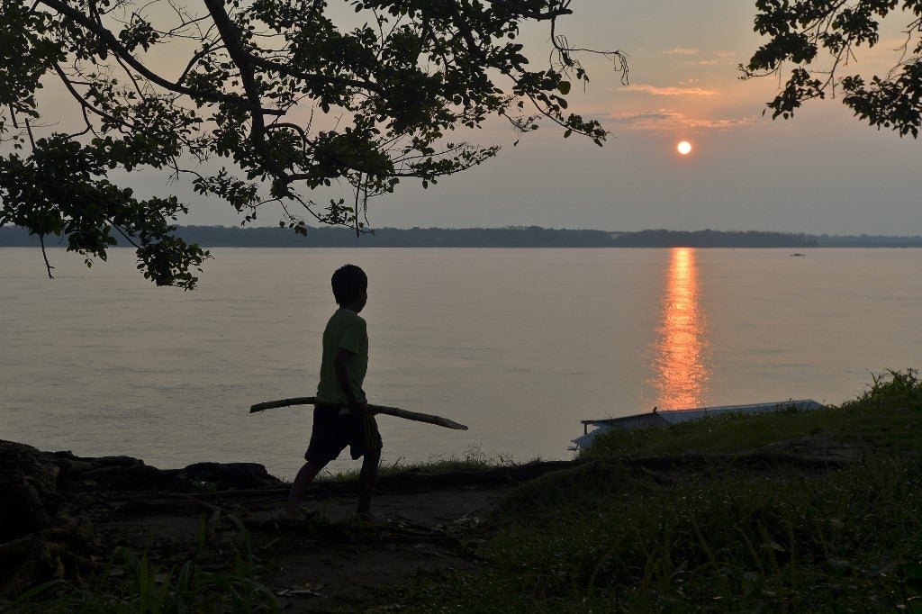 Un niño indígena colombiano camina a orillas del río Amazonas.