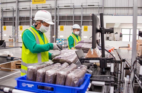 Trabajadores en centro de despacho de Mercado Libre