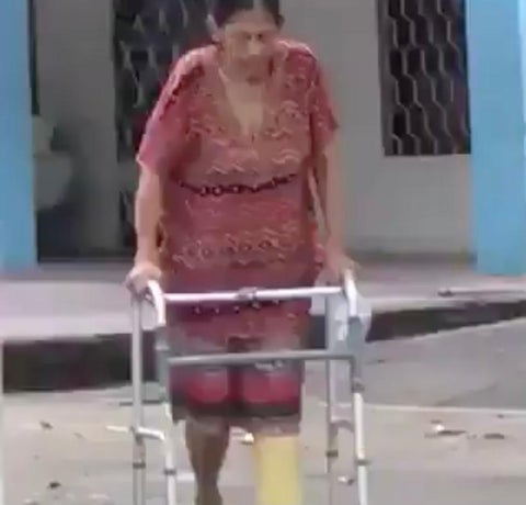 La mujer utiliza un tubo de PVC para poder caminar.