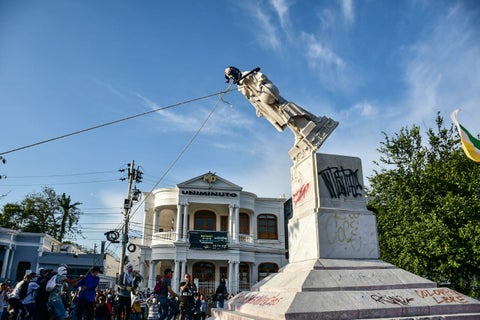 Manifestantes derriban estatua de Cristobal Colon.