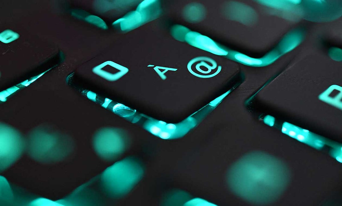 Teclado de computador de color negro con luces azules