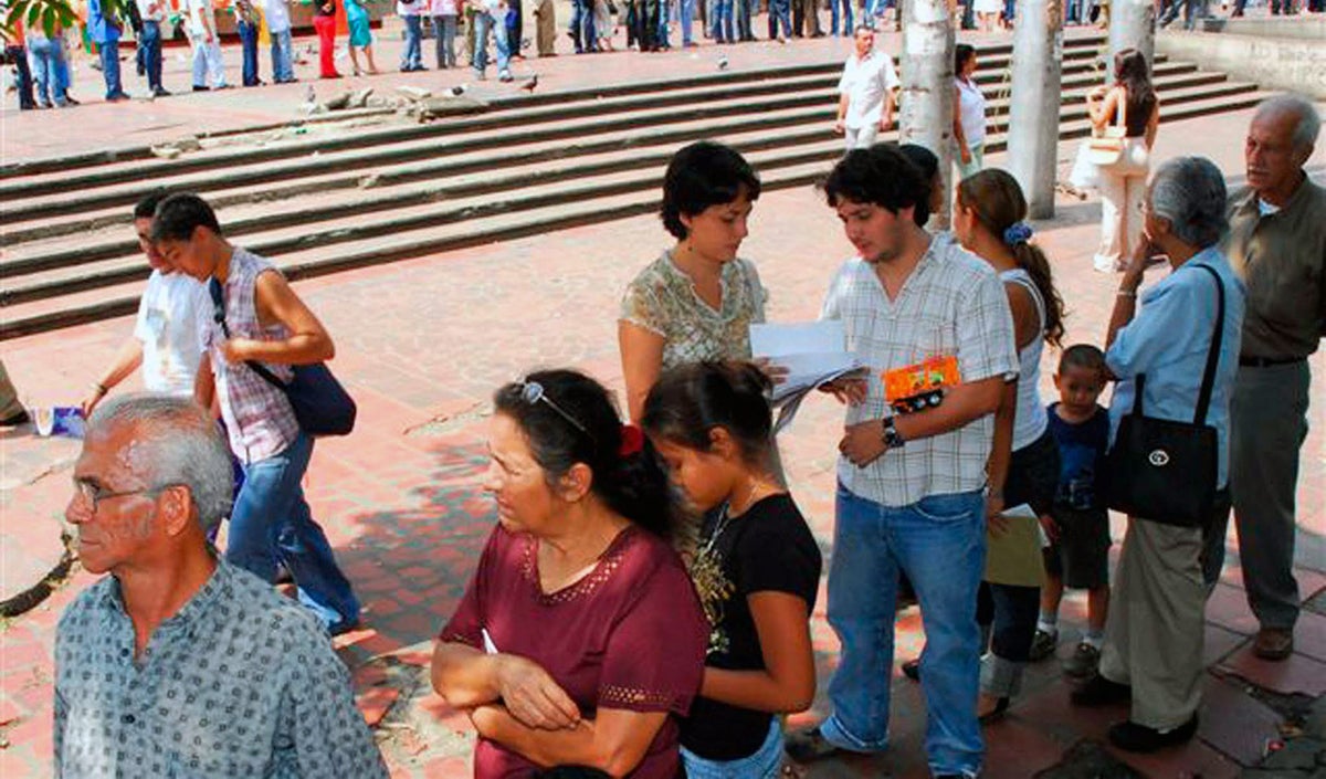 Personas hacen fila para realizar trámites
