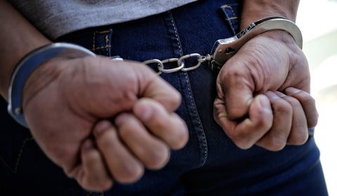 Hombre detenido con esposas