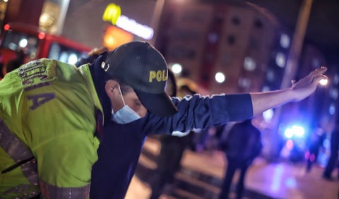 Policía requisa a un ciudadano en calle de Bogotá.
