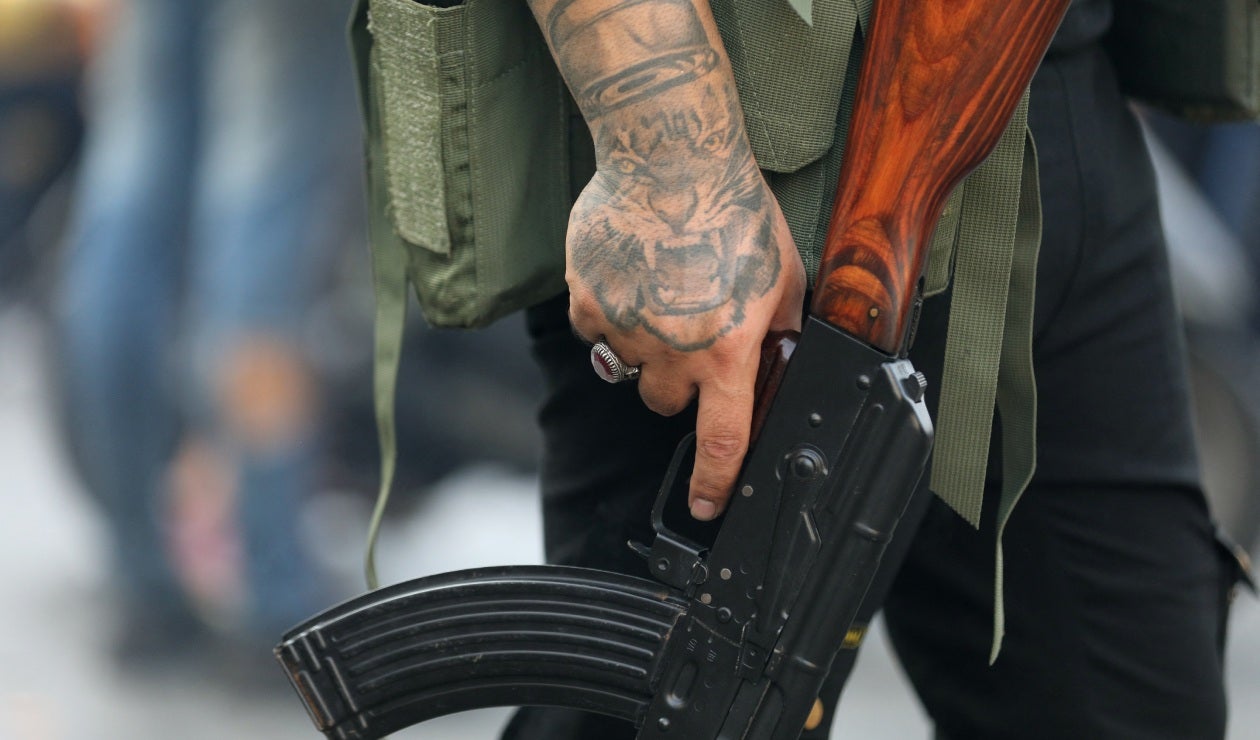 Miembro de Hezbolá sostiene su arma durante un funeral por muerte de terroristas
