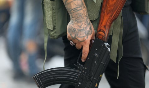 Miembro de Hezbolá sostiene su arma durante un funeral por muerte de terroristas