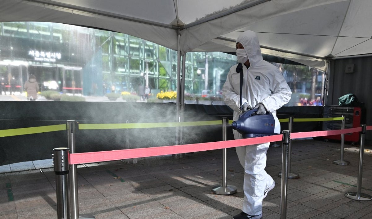 Hombre desinfecta lugar en Corea del Sur por la aparición de Omicron