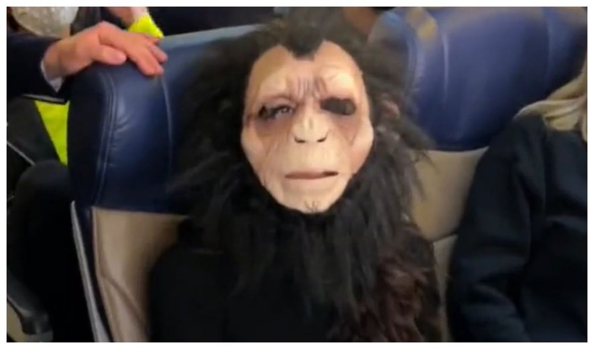 Mujer con máscara de mono en avión