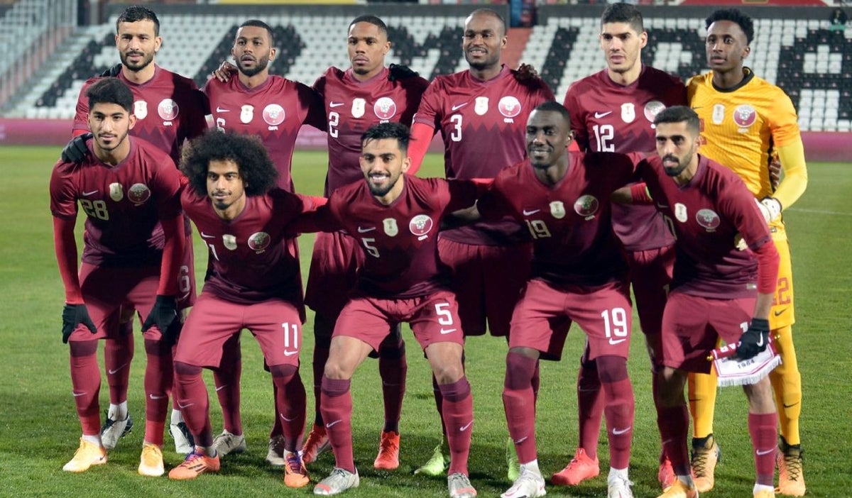 Deportistas uniformados posando para una foto en un campo de fútbol