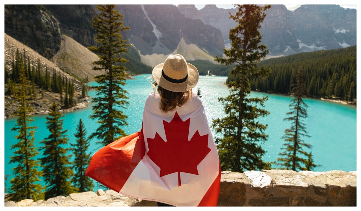 Mujer mirando la panorámica con bandera de Canadá