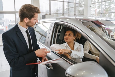 Mujer entregando las llaves de un carro a u hombre