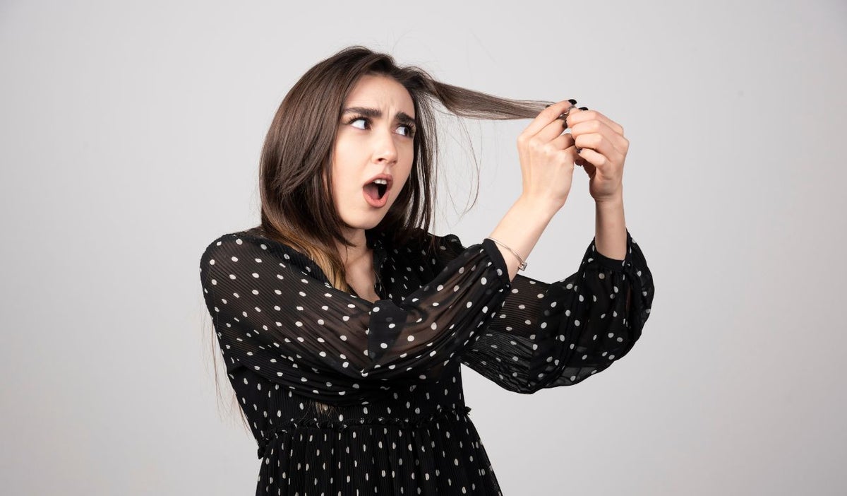 Mujer mirándose el cabello- horquilla en el cabello