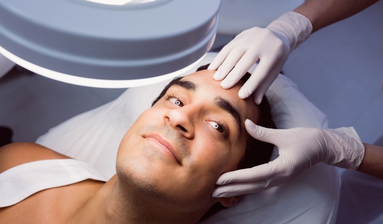 Doctora examinando piel de un hombre: melanoma qué es y cómo se diagnóstica