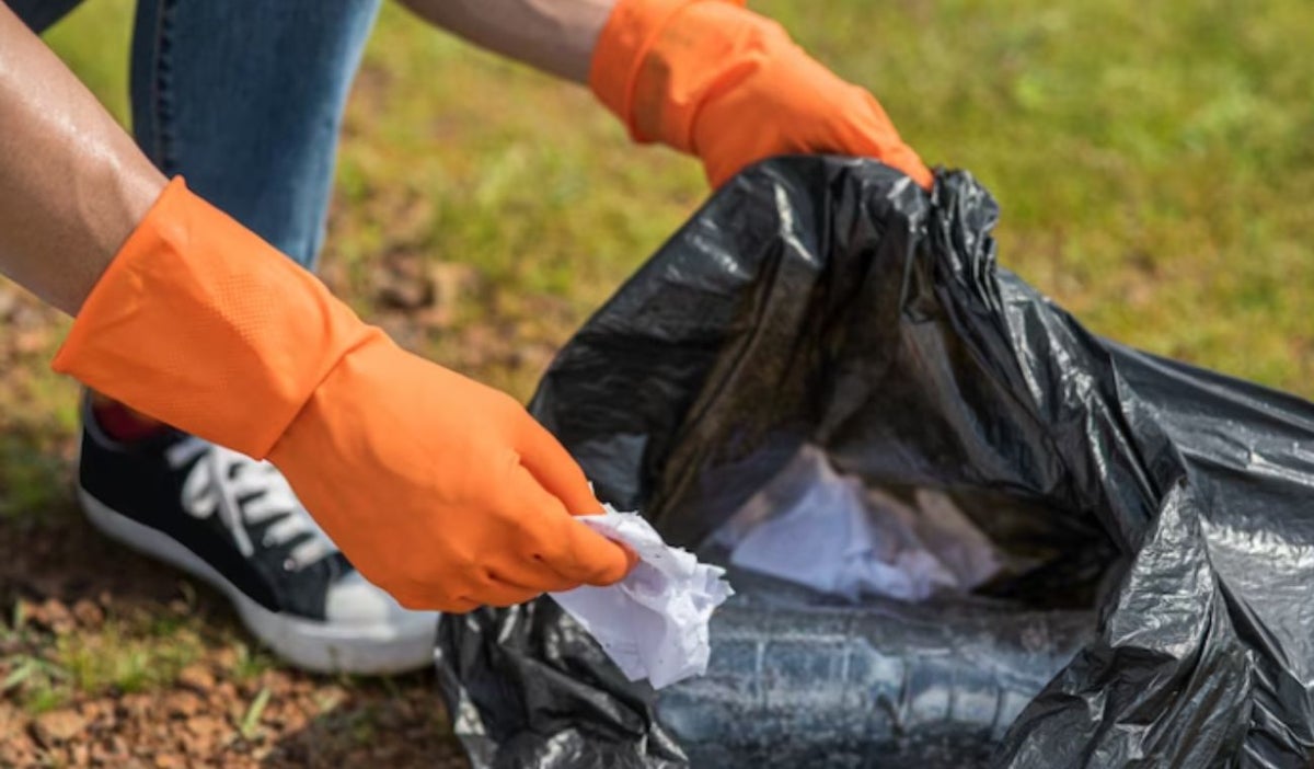 Persona recogiendo basura: plogging modalidad en deporte
