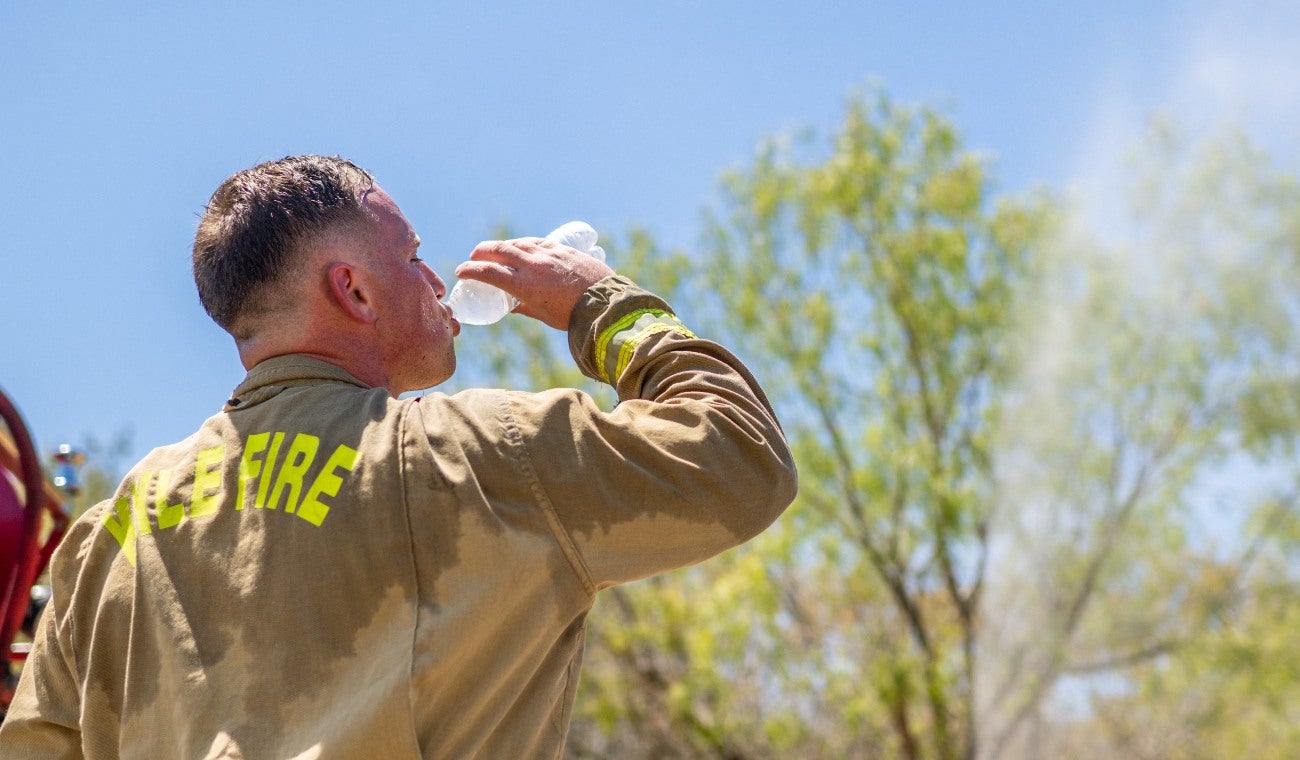 Ola de calor en Austin, Texas. Un bombero toma un descanso de los trabajos de apagar un incendio
