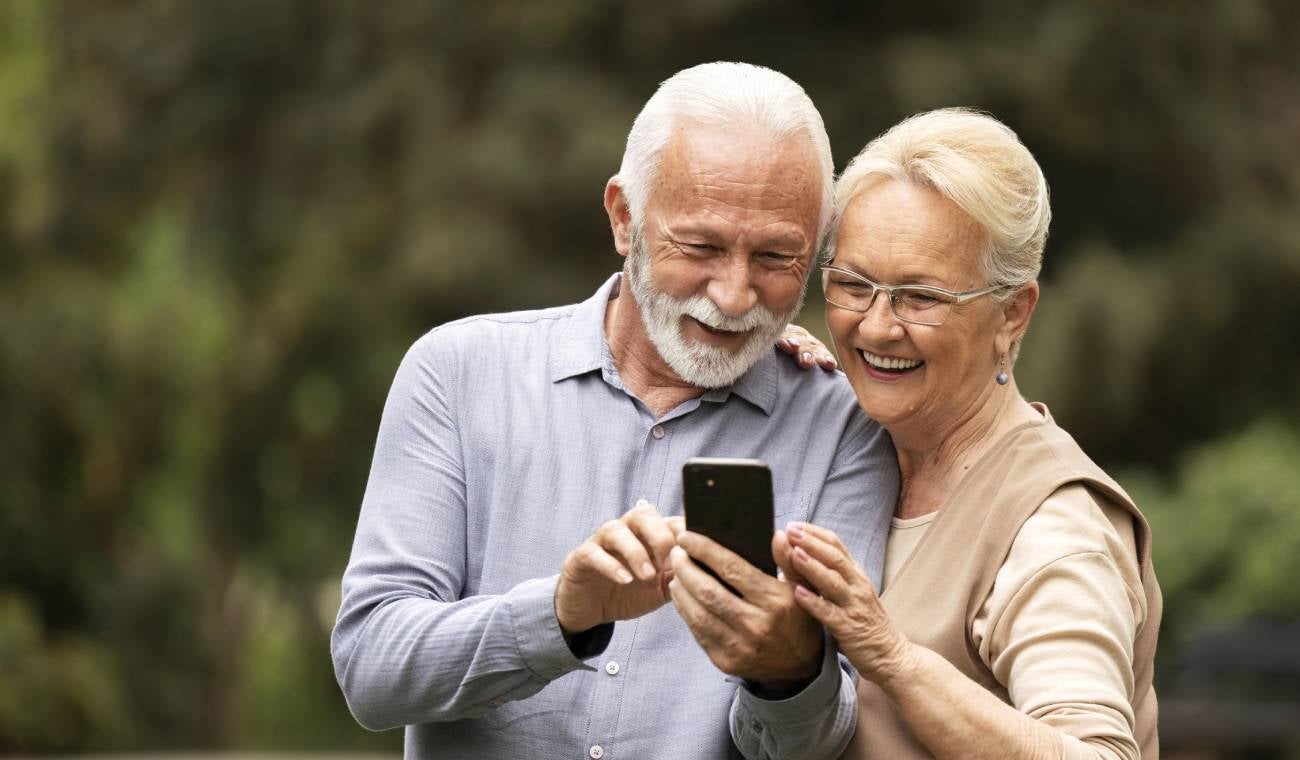 Personas de la tercera edad utilizando un celular