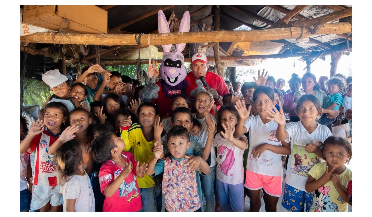Niños recibiendo kits de Colgate