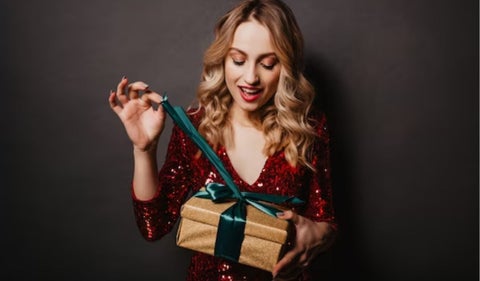 Mujer abriendo un regalo de Navidad