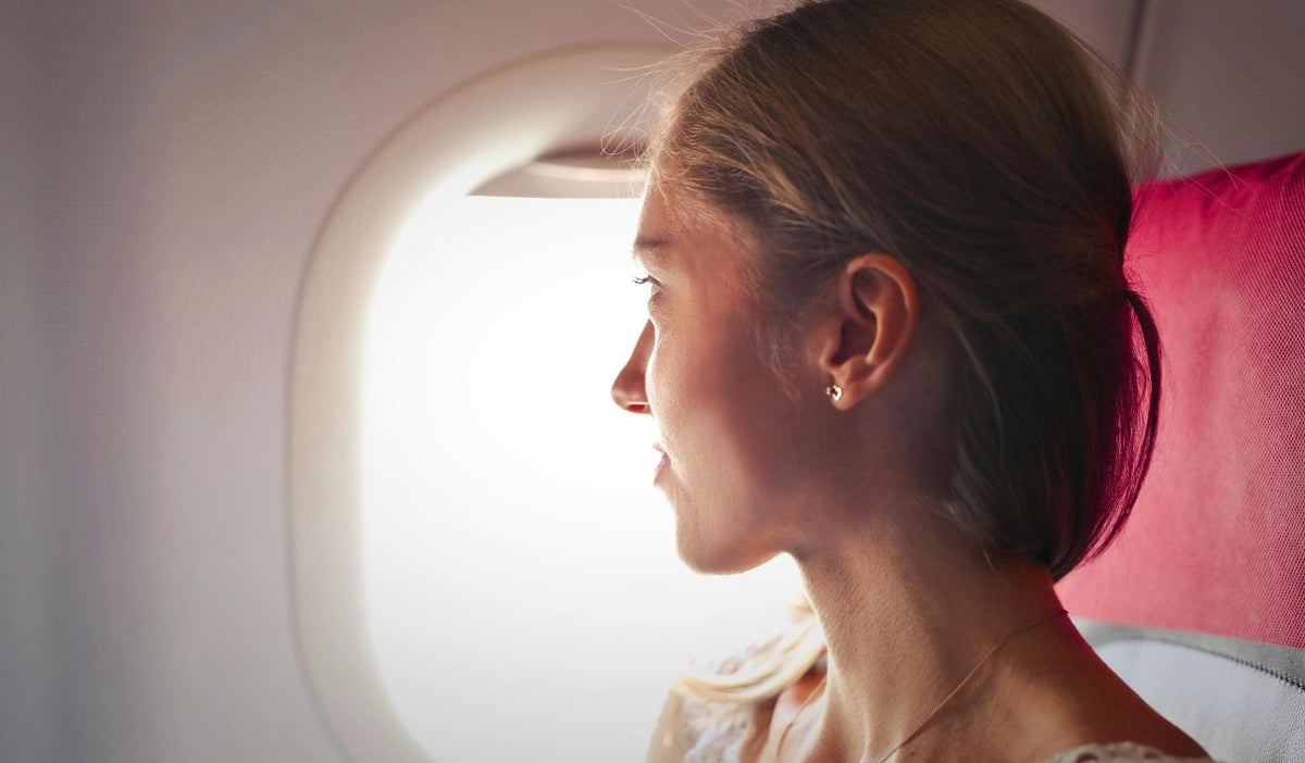 Mujer mirando por la ventanilla de un avión