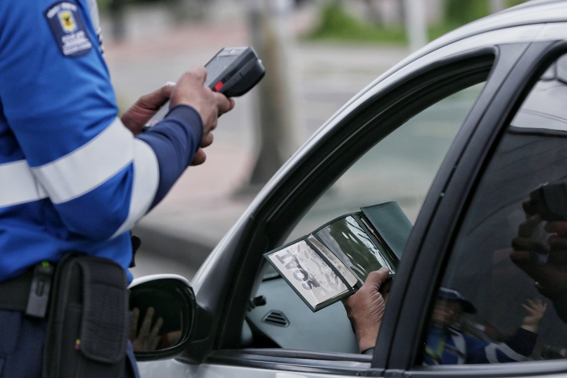 Policía de tránsito pidiendo el SOAT a conductor en Colombia