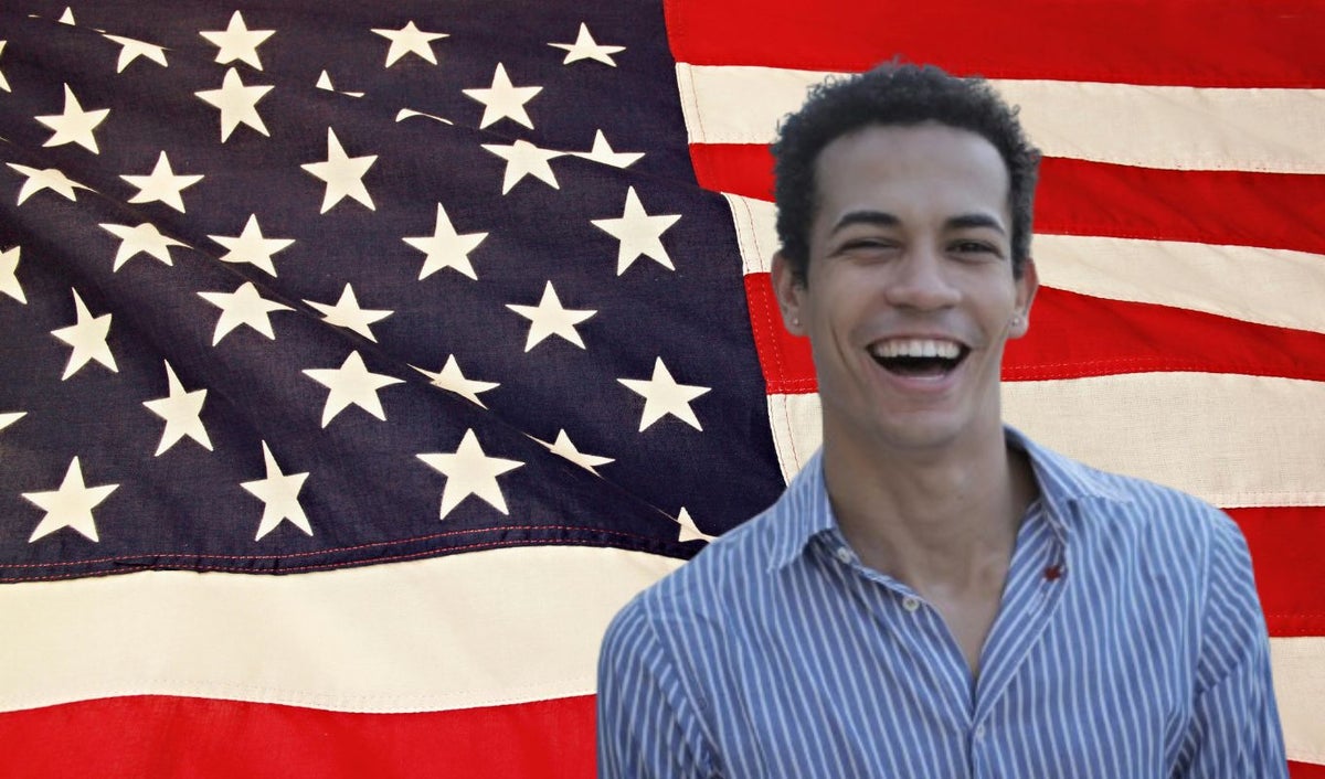Bandera de Estados Unidos y hombre latino sonriendo