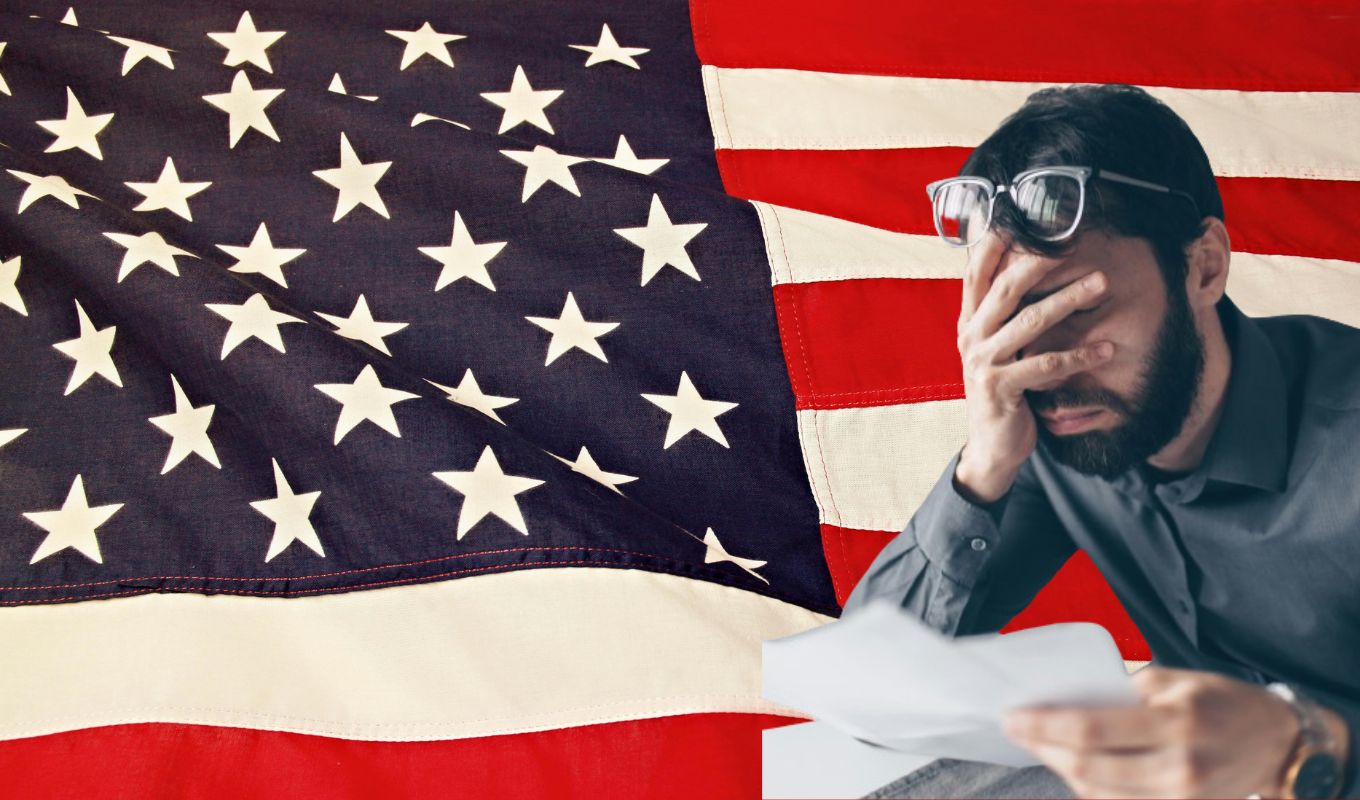 Bandera de Estados Unidos y un hombre preocupado con la mano en la cabeza