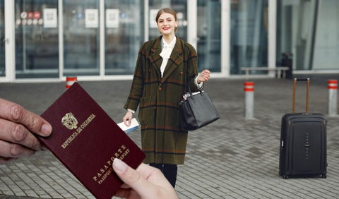 Mujer con maleta de viaje y pasaporte colombiano