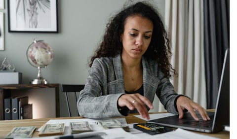 Mujer con billetes y calculadora