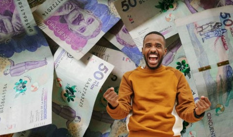 Billetes al fondo y persona celebrando