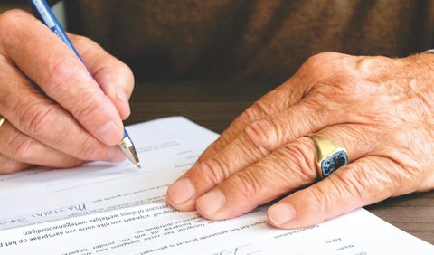 Hombre mayor firmado un documento