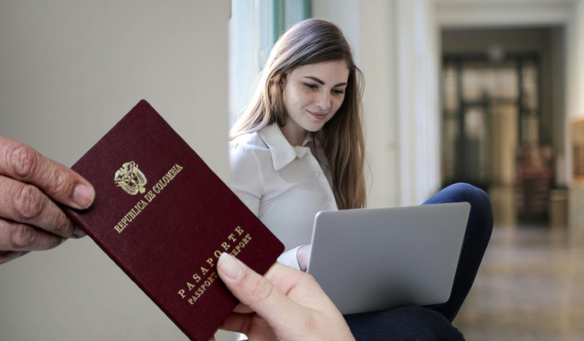 Mujer con computador y el pasaporte